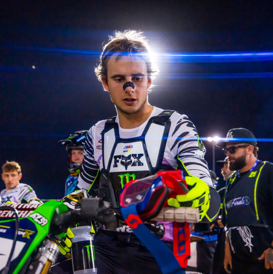 Levi Kitchen grabbing goggles of dirt bike handlebar